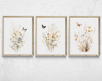 May include: Three framed watercolor prints featuring delicate floral arrangements with butterflies. The prints are in a light wood frame and have a white background.