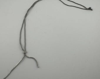 Collar de cadena vintage en tono plateado con detalle decorativo.
