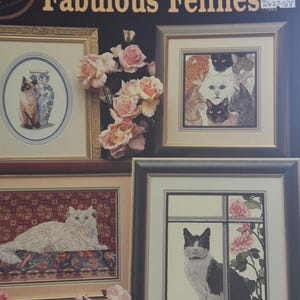 May include: Cross stitch pattern booklet featuring four different cat designs. The cover features the title "Fabulous Felines" and a price tag of £5.50. The designs include a white cat with blue eyes, a black and white cat, a white cat with orange eyes, and a group of cats with various colours and patterns.