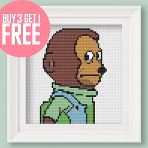 May include: Cross-stitch pattern of a brown monkey wearing a green and blue shirt. The monkey has a serious expression and is looking to the right. The pattern is framed in a white frame.