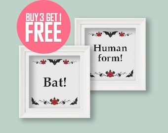 May include: Two white framed cross-stitch pieces with black bats and red roses. The top piece says "Human form!" and the bottom piece says "Bat!"
