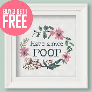 May include: A white framed cross-stitch with a floral wreath and the text "Have a nice POOP".