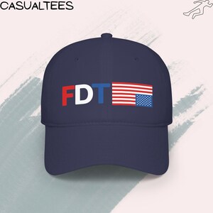 Low-profile baseball cap displaying an FDT graphic with an inverted U.S. flag, representing political dissent and resistance to Trump-era leadership.