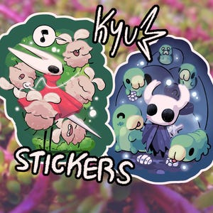 Op de afbeelding: Twee stickers met stripfiguren. Eén sticker heeft een rood en wit personage met een muzieknoot en andere personages op een groene achtergrond. De tweede heeft een wit personage met een cape en andere personages op een blauwe achtergrond. Het woord "STICKERS" staat onderaan de eerste sticker.
