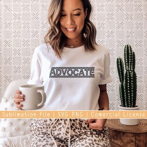 May include: White t-shirt with the word "ADVOCATE" printed in black and white checkered pattern.