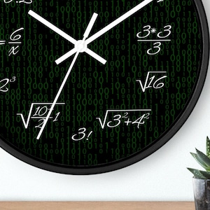May include: A black and green clock with white hands and a black frame. The clock face has a binary code pattern with mathematical equations written on it. The equations include 36/3, √4/2, 2^6/3π, 3*3/3, √16, √10/1, 3!, and √3+4^2.