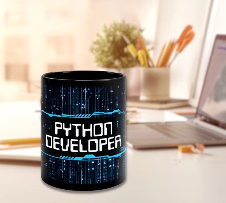 May include: Black ceramic mug with a blue and white graphic design that says "Python Developer". The design features a digital pattern of lines and circuits.