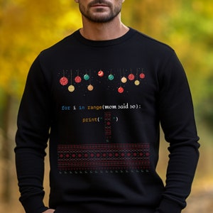 K&ouml;nnte beinhalten: Schwarzer Pullover mit einem Weihnachtsbaum-Design, das einen Code-Ausschnitt mit der Aufschrift "for i in range(mom said so): print('')" zeigt.
