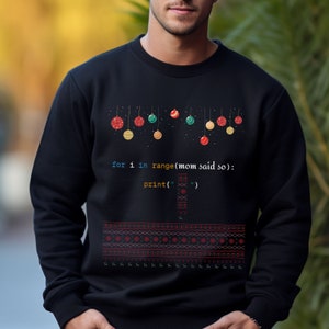 K&ouml;nnte beinhalten: Schwarzer Pullover mit einem Weihnachtsbaum-Design mit bunten Kugeln und dem Code "for i in range(mom said so):
print(" ")".