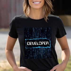 Może przedstawiać: Czarny T-shirt z niebiesko-białym nadrukiem płytki elektronicznej i napisem "DEVELOPER" w niebieskim prostokącie.