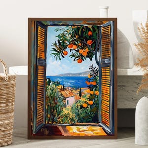 May include: A framed painting depicts a vibrant coastal scene viewed through an open window with shutters. The artwork showcases a blue sea, orange trees, and buildings. The frame is dark brown, and the painting is set against a neutral background.