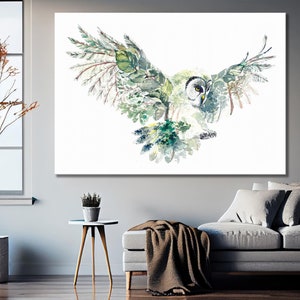 K&ouml;nnte beinhalten: Ein Aquarellbild eines Eulen mit gr&uuml;nen und blauen Bl&auml;ttern als Fl&uuml;gel, das vor einem wei&szlig;en Hintergrund fliegt.