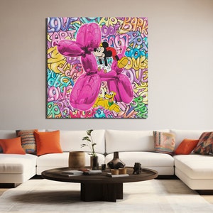 K&ouml;nnte beinhalten: Ein rosa Ballonhund mit Mickey Mouse und Pluto, die darauf reiten. Der Hintergrund ist ein buntes Graffiti-Muster mit W&ouml;rtern wie "love", "art" und "park".