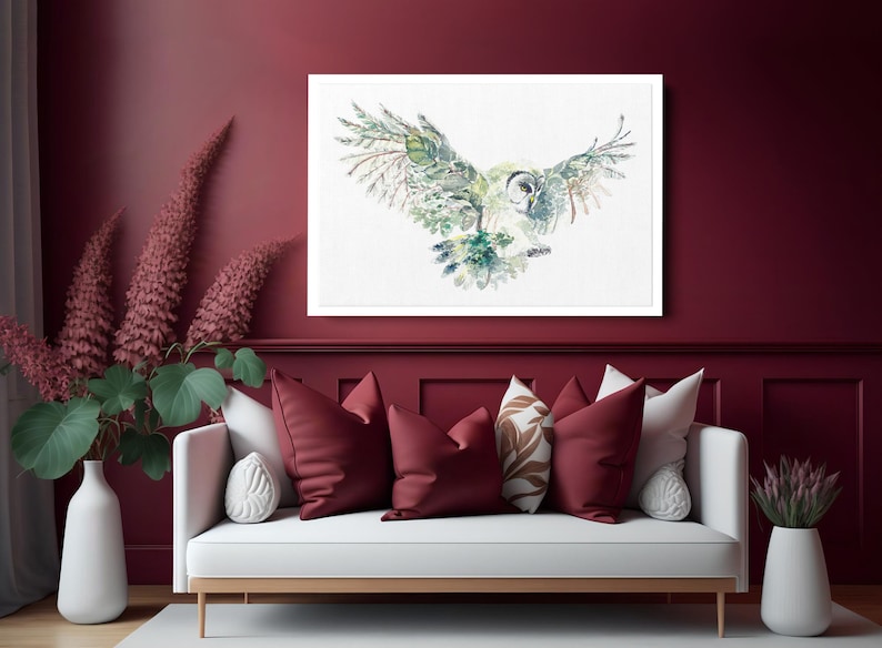 K&ouml;nnte beinhalten: Ein Aquarellbild eines Eulen mit ausgebreiteten Fl&uuml;geln. Die Eule ist in Gr&uuml;n-, Braun- und Wei&szlig;t&ouml;nen dargestellt und vor einem wei&szlig;en Hintergrund platziert. Das Bild ist in einem wei&szlig;en Rahmen gerahmt und h&auml;ngt an einer burgunderfarbenen Wand.