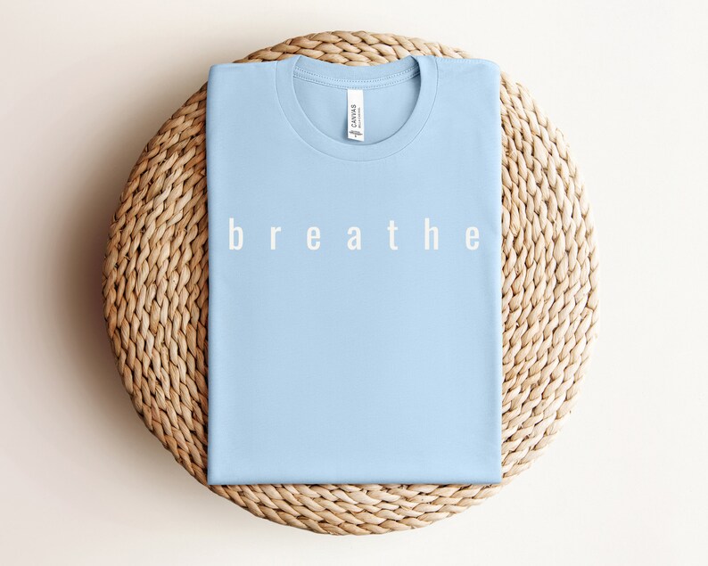 May include: A light blue t-shirt with the word "breathe" printed in white on the front.