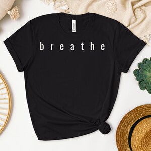 May include: Black t-shirt with the word "breathe" printed in white on the front.