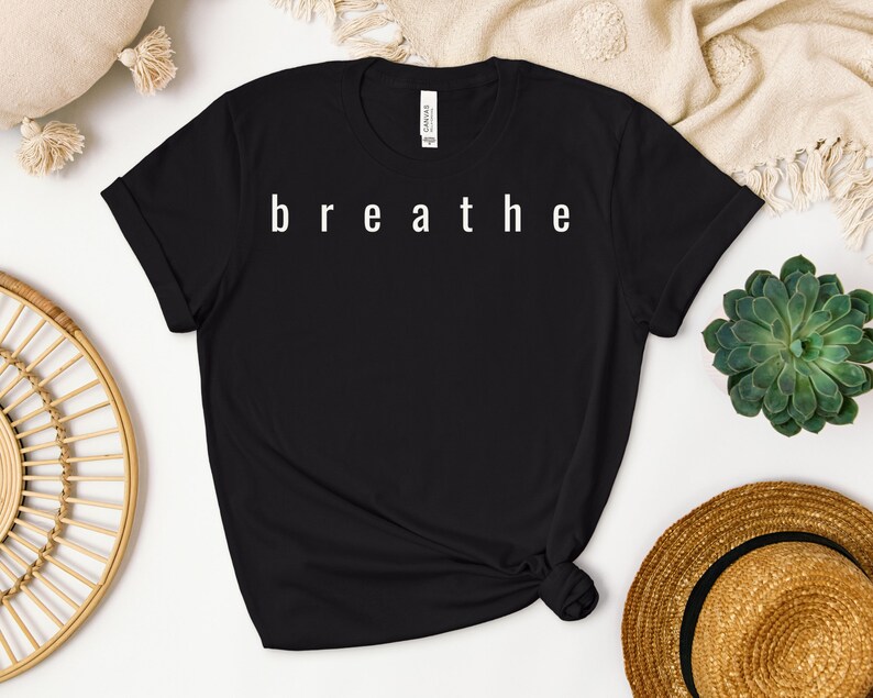 May include: Black t-shirt with the word "breathe" printed in white on the front.