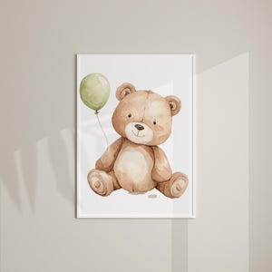 May include: Watercolor illustration of a teddy bear holding a green balloon. The bear is light brown with a cream-colored belly and a small black nose. The artwork is framed in a white border, suitable for nursery decor.