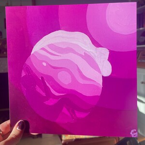 May include: An abstract painting featuring a layered, spherical form in shades of pink and purple. The artwork has a gradient effect, with lighter hues at the top and darker shades at the bottom. The background includes circular shapes in varying shades of pink.
