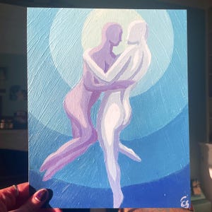 May include: An acrylic painting depicts two figures embracing, rendered in shades of purple and white against a backdrop of concentric blue circles. The artwork has a textured appearance, with visible brushstrokes. The painting is held by a hand with a painted fingernail.
