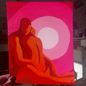 May include: An abstract painting featuring two figures embracing, rendered in shades of orange and red. The background showcases a gradient of pink hues, with a central white circle. The artwork evokes a sense of warmth and intimacy.