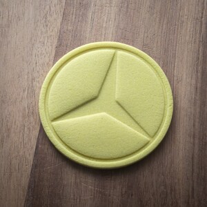 May include: A yellow, round, three-sectioned, decorative object with a raised, textured design.