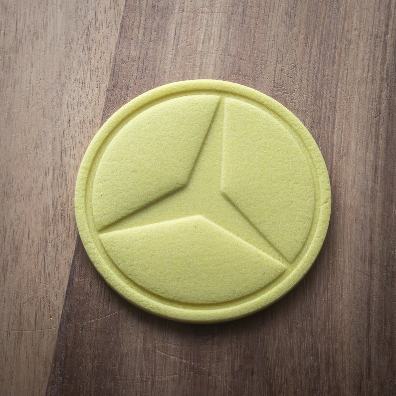May include: A yellow, round, three-sectioned, decorative object with a raised, textured design.