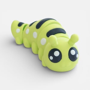 May include: A lime green caterpillar toy with black and white accents. The segmented body features black stripes and white polka dots. The caterpillar has large, expressive eyes and small antennae, giving it a friendly appearance.