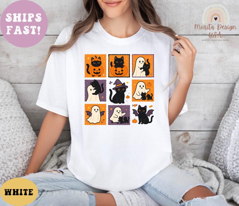 May include: White t-shirt featuring a grid of Halloween-themed illustrations. Each square showcases a black cat, ghost, or bat with pumpkins and witch hats. The shirt has the text "WHITE" and "SHIPS FAST!"