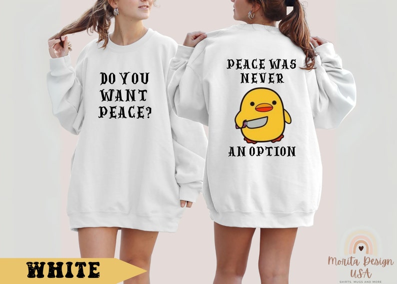 K&ouml;nnte beinhalten: Wei&szlig;er Pullover mit dem Text "Do you want peace?" auf der Vorderseite und "Peace was never an option" mit einem Cartoon-gelben K&uuml;ken, das ein Messer h&auml;lt, auf der R&uuml;ckseite.