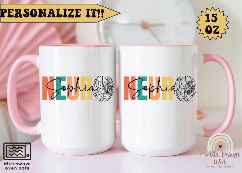 Op de afbeelding: Twee witte 440 ml mokken met roze handvatten. De mokken hebben een kleurrijk ontwerp met het woord "Neuro" en de naam "Sophia" in een regenboog-lettertype. Aan de rechterkant van elke mok staat een brein met bloemen.