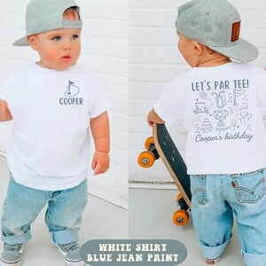 May include: A white t-shirt featuring a small golf flag graphic and the name Cooper on the front, with a larger golf-themed design on the back that reads Let's Par Tee! Cooper's birthday, paired with light blue jeans and a gray baseball cap.