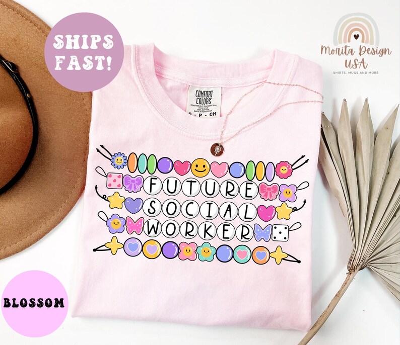 May include: A light pink t-shirt with the words "FUTURE SOCIAL WORKER" in a circle font. The shirt has colorful beaded accents and a necklace. The shirt also has the text "SHIPS FAST!" and "BLOSSOM".