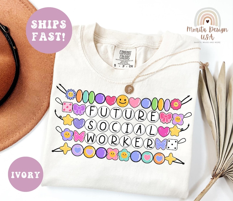 May include: Ivory-colored t-shirt with the text "FUTURE SOCIAL WORKER" in a circle font, decorated with colorful cartoon beads, hearts, and flowers. The shirt also has the text "SHIPS FAST!" and "IVORY" in a circle.