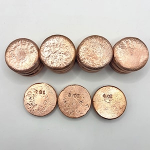 May include: Copper rounds in various stacks and sizes. The rounds have a textured surface and are stamped with their weight in ounces: 2 oz, 8 oz, and 6 oz. The copper has a warm, reddish-brown color.