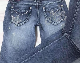 Jeans acampanados de tiro bajo con estampado de estrellas y lavado medio de Akademiks, estilo años 2000. Un look glam grunge impecable. Una prenda gyaru.
