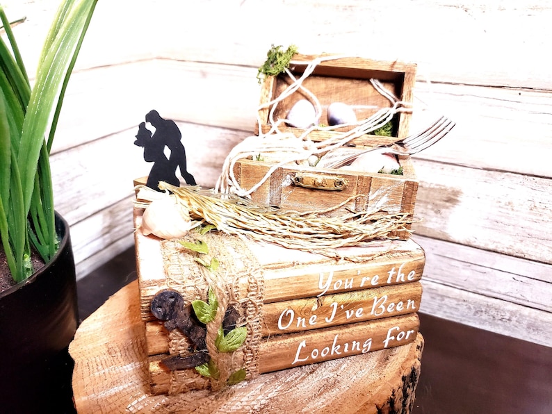 K&ouml;nnte beinhalten: Rustikale Holzringbox mit einer Silhouette eines tanzenden Paares auf der Oberseite. Die Box ist mit Sackleinen, Schnur und Gr&uuml;n verziert. Der Deckel der Box tr&auml;gt den Text "You're the One I've Been Looking For".
