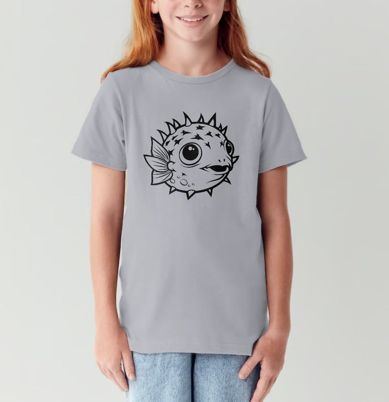 May include: A light gray t-shirt with a black and white illustration of a pufferfish on the front.