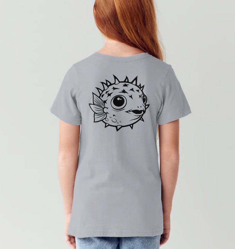 May include: A light gray t-shirt with a black and white illustration of a pufferfish on the back.