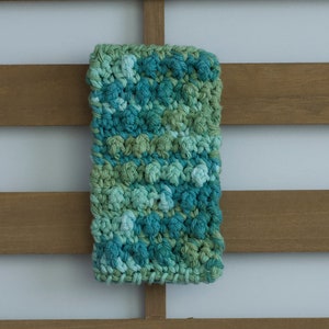 Puede incluir: Un paño de cocina de crochet verde y azul con un patrón texturizado.