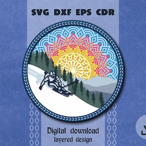 Peut inclure: Un téléchargement numérique d'un design en couches représentant un skieur sur une montagne enneigée avec un soleil mandala coloré en arrière-plan. Le design est parfait pour créer des objets artisanaux en papier, tels que des cartes, des décorations, et plus encore.