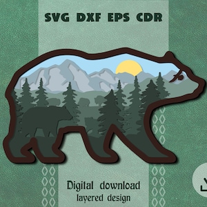 May include: A layered papercraft design of a bear silhouette with a mountain landscape inside. The bear is brown, the mountains are blue and grey, and the sky is blue with a yellow sun. There are trees and a bird in the scene.