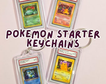 Op de afbeelding: Vier Pokemon Starter sleutelhangers met Charizard, Blastoise, Venusaur en Pikachu kaarten. Elke kaart is ingesloten in een doorzichtige plastic houder met een metalen sleutelhanger. De tekst "Pokemon Starter Keychains" wordt weergegeven.