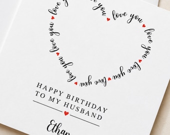 May include: A white square greeting card featuring a heart shape formed by the repeated black text "love you" interspersed with small red hearts. Below, the text reads "HAPPY BIRTHDAY TO MY HUSBAND" with a red heart and the name "Ethan".