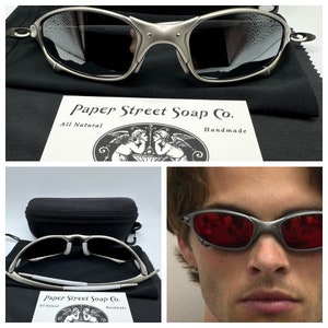 May include: Silver-framed sunglasses with dark lenses, displayed with a black case and cleaning cloth. The image also includes a card with the text "Paper Street Soap Co. All Natural Handmade."