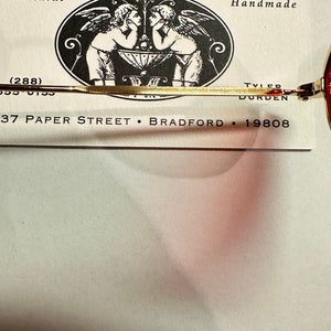 Może przedstawiać: Wizyt&oacute;wka firmy Paper Street Soap Co., producenta ręcznie robionego mydła. Na wizyt&oacute;wce znajduje się czarno-biała ilustracja dw&oacute;ch anioł&oacute;w z skrzydłami, logo i adres firmy: 37 Paper Street, Bradford, 19808.