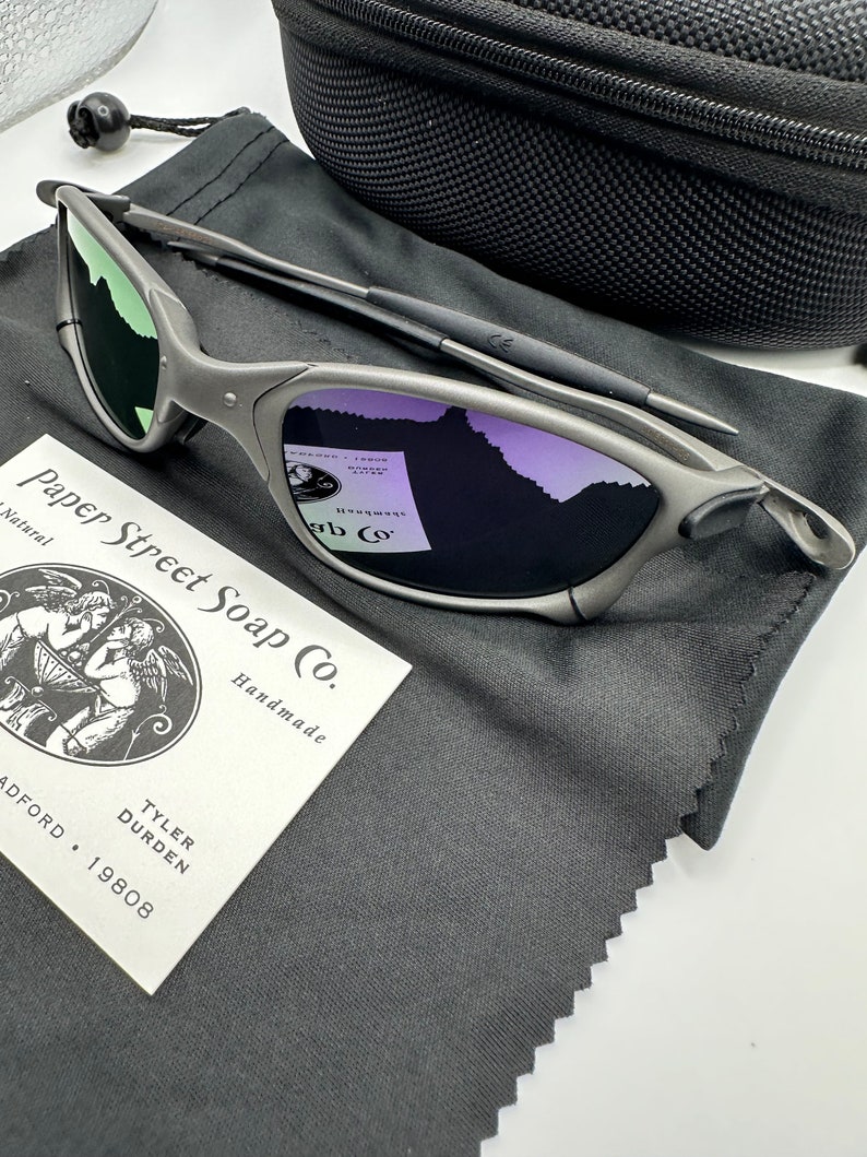 May include: A pair of silver-colored sunglasses with a black microfiber cleaning cloth and a small business card that reads "Paper Street Soap Co. Handmade Tyler Durden Radford 19808".