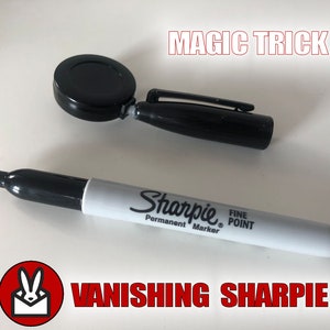 May include: A black magic trick prop with a black Sharpie permanent marker labelled "Fine Point" and the text "Vanishing Sharpie" in red.
