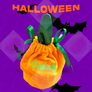 Op de afbeelding: Oranje fluwelen trick-or-treat tasje in de vorm van een pompoen met een groene steel en een groen lint. De tas is geborduurd met het woord "Penny".