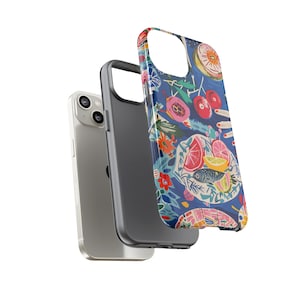 May include: A silver smartphone with a black case and a patterned phone case. The patterned case features a blue background with colorful illustrations of fruit, flowers, and a fish.